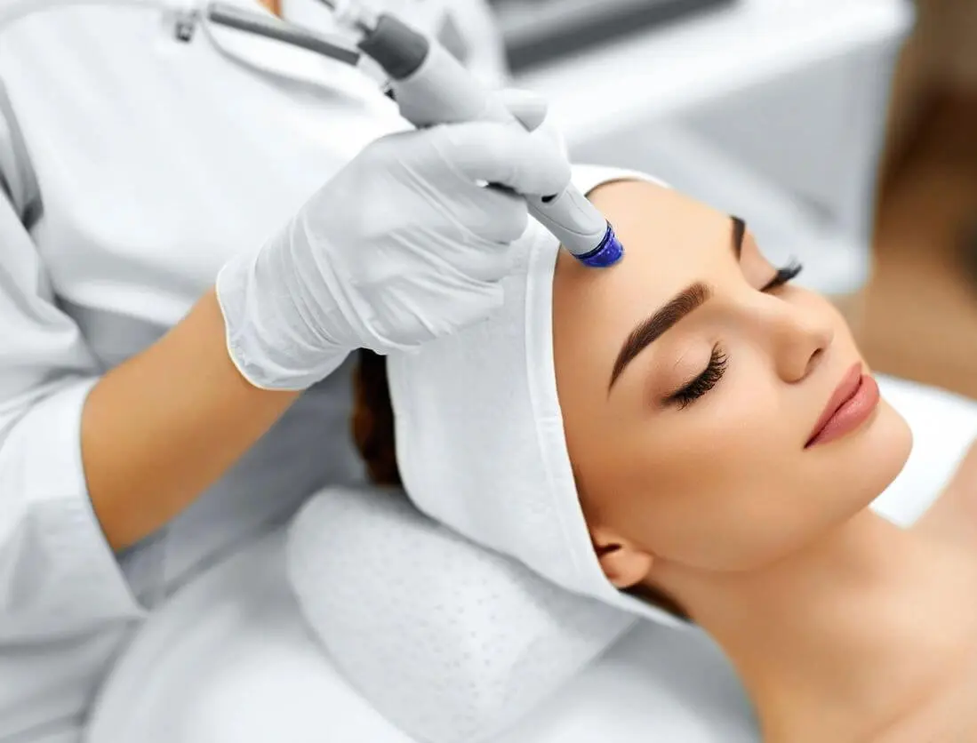 A woman getting her face waxed at the spa